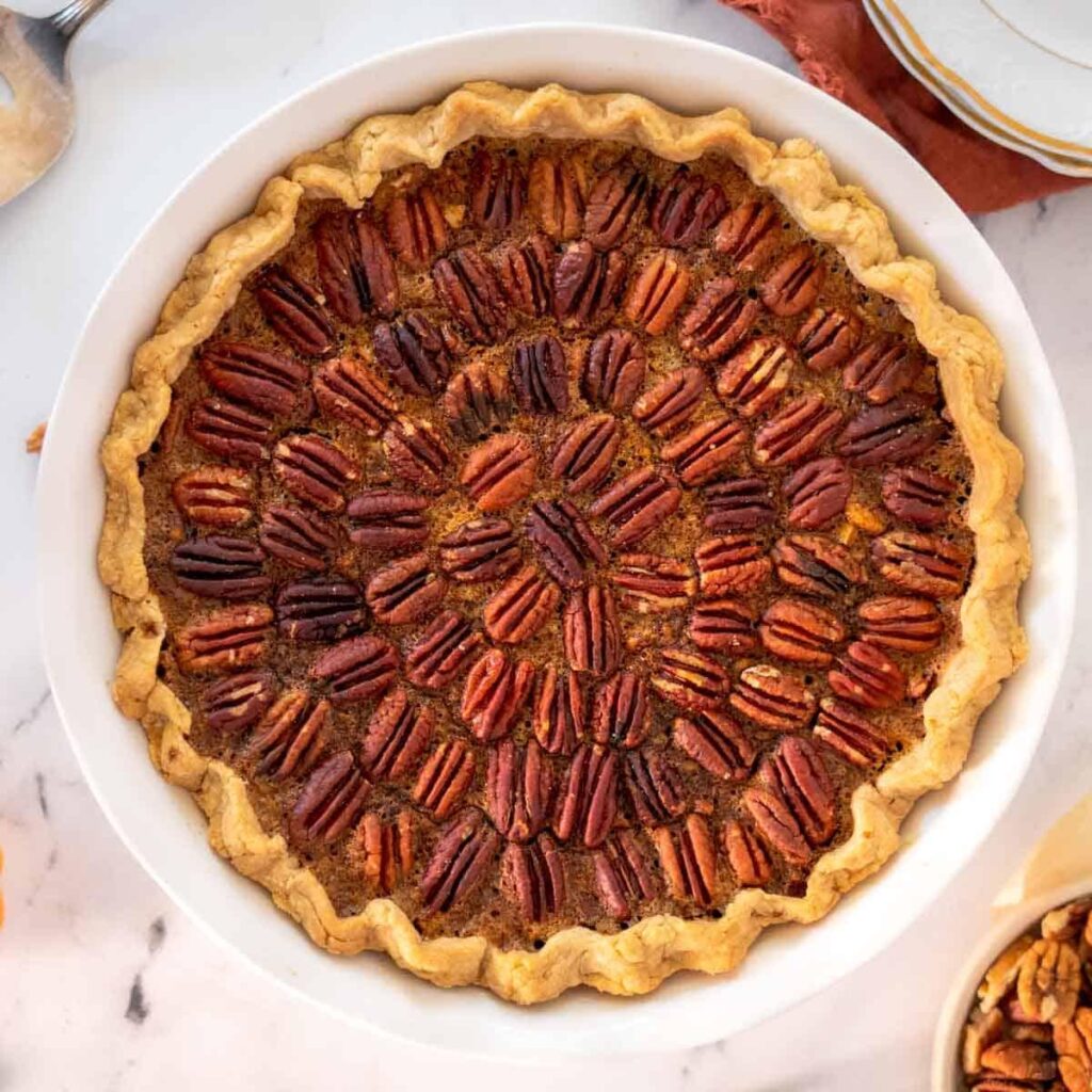 Rich gluten free pecan pie with a flaky golden crust and caramelized pecan filling.